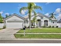 Charming single-story home with a lush front lawn and mature palm trees at 1034 Alvina Ln, Oviedo, FL 32765