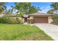 Inviting single-story home with a lush green lawn, mature trees, and a spacious driveway at 11 Huntley Ct, Haines City, FL 33844