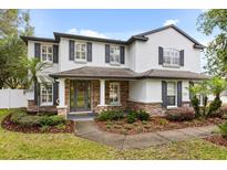 Beautiful two-story home with stone accents, a covered front porch, and a well-manicured lawn at 141 Dommerich Dr, Maitland, FL 32751