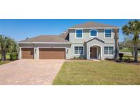 Charming two-story home featuring a three-car garage, lush lawn, and manicured landscaping at 14537 San Lorenzo Dr, Orlando, FL 32820