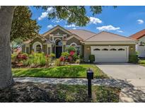 Charming single-story home with tile roof, lush landscaping, and a two-car garage at 1855 Vista Royale Blvd, Orlando, FL 32835