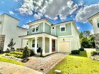 Charming two-story home featuring a covered porch, attached garage, and beautifully landscaped front yard at 2034 Fleming Mist Pl, Kissimmee, FL 34747