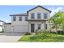 Charming two-story home with white siding, grey trim, landscaped yard, and a welcoming front porch at 2294 Gold Dust Dr, Minneola, FL 34715