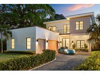 Stunning modern home featuring a two-car garage, elegant balcony, and a manicured lawn at 2412 Chantilly Ave, Winter Park, FL 32789