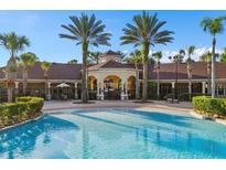 Community pool with clear blue water, palm trees, and clubhouse providing a resort-style living experience at 2778 Almaton Loop # 302, Kissimmee, FL 34747