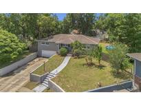 Charming single-story home with a well-manicured front yard, integrated garage, and mature trees creating a private setting at 300 Hickory Ct, Apopka, FL 32712