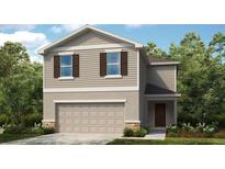 Charming two-story home featuring a two-car garage and a welcoming front porch at 306 Wayland Dr, Haines City, FL 33844