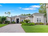 Stunning single-story home featuring a brick driveway, manicured landscaping, and elegant architectural details at 3400 Rose Mallow Loop, Oviedo, FL 32766