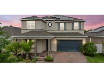 Charming two-story home with a well-maintained front yard, brick driveway, and solar panels on the roof at 4783 Riverwalk Dr, St Cloud, FL 34771