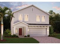 Charming two-story home features a two-car garage, well-maintained lawn and tropical landscaping at 7116 Cherry Pasture Rd, Groveland, FL 34736