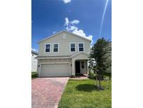 Charming two-story home featuring a red brick driveway, well-maintained lawn and attractive landscaping at 7116 Cherry Pasture Rd, Groveland, FL 34736