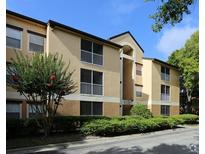 Spacious condominium building with a well-maintained facade and lush landscaping at 7606 Pissarro Dr # 14206, Orlando, FL 32819