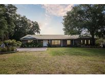 Charming single-story brick home featuring a metal roof and a well-maintained lawn at 949 Shadow Oaks Rd, Kissimmee, FL 34744