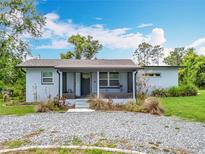 Charming single-story home featuring front porch, landscaped yard, and ample greenery surrounding the property at 9506 Number Two Rd, Howey In The Hills, FL 34737