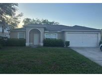Charming single-story home featuring a lush lawn, manicured shrubs, and an attached two-car garage at 970 Courtland Blvd, Deltona, FL 32738
