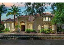 Charming home featuring a red tile roof, lush landscaping, and an inviting front entrance with archways at 1070 Henley Downs Pl, Lake Mary, FL 32746