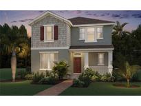Charming two-story home with a combination of siding and shingles and a well-manicured lawn and landscaping at 11182 Hollow Bay Dr, Winter Garden, FL 34787