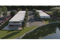 Stunning aerial view of modern townhomes with a community pool and beautifully landscaped grounds near the water at 11302 Westwood Blvd # 28, Orlando, FL 32821