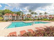 Resort-style pool area with palm trees and plenty of lounge chairs for relaxing by the water at 11526 Westwood Blvd # 735, Orlando, FL 32821