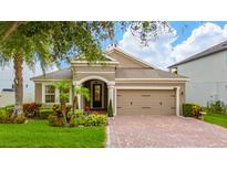 Charming single-story home with a well-manicured lawn and a welcoming arched entryway leading to the front door at 15862 Citrus Grove Loop, Winter Garden, FL 34787