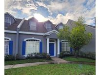 Charming townhouse with blue shutters, a blue front door, and a well-manicured lawn at 2157 Island Walk Dr, Orlando, FL 32824