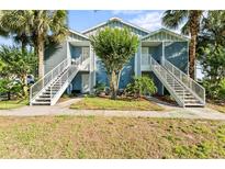 Charming condo building featuring exterior stairs, tasteful landscaping and mature palm trees in a well maintained community at 2501 Grassy Point Dr # 103, Lake Mary, FL 32746