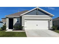 Charming home exterior with a two-car garage and well-maintained landscaping at 2963 Waterlily Way, Poinciana, FL 34759