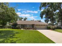 Charming one-story home features a well-manicured lawn, mature trees, and a neutral exterior color scheme at 3300 Se 22Nd Ave, Ocala, FL 34471