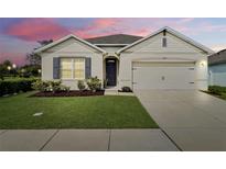Charming single-story home showcasing a manicured lawn, neutral tones, and an attached two-car garage at 3329 Royal Tern Dr, Winter Haven, FL 33881