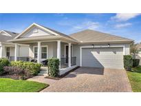 Charming single-story home featuring a covered front porch and a two-car garage at 338 Wooded Vine Dr, Winter Springs, FL 32708