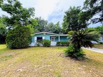 Charming single-story home featuring vibrant curb appeal with mature trees and well-kept lawn at 605 Pleasantdale Dr, Wildwood, FL 34785