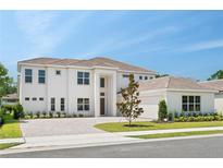 Stunning two-story home featuring a brick driveway, manicured lawn, and a neutral color palette at 6125 Village Edge Pl, Sanford, FL 32771