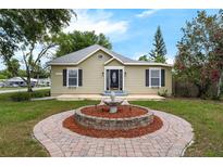 Charming home featuring a manicured lawn with a lovely decorative fountain feature at the entrance at 803 Jersey Ave, St Cloud, FL 34769