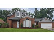 Charming two-story brick home with landscaped yard, mature trees and a two car garage at 8612 Valley Ridge Ct, Orlando, FL 32818