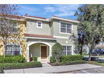 Charming two-story townhome with a well-maintained lawn, neat shrubbery, and a decorative tile roof at 8919 Bismarck Palm Rd, Kissimmee, FL 34747