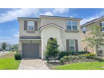 Charming two-story home with a well-maintained lawn and neutral-colored stucco exterior at 8940 Coconut Breeze Dr, Kissimmee, FL 34747