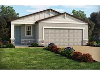 Charming single-story home with a two-car garage and beautifully landscaped front yard with vibrant flowers at 903 Donahue Pass, Lake Hamilton, FL 33851