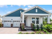Charming single-Gathering home boasting a two-car garage, welcoming front porch, and nicely manicured front yard landscaping at 11003 Hollow Bay Dr, Winter Garden, FL 34787