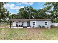 Charming single-story home with a covered front porch and a combination of white and gray exterior at 1341 W Belmar St, Lakeland, FL 33815