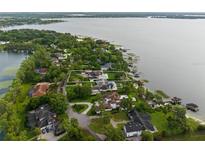 Aerial view of a large waterfront estate with a pool, boat dock and lush landscaping at 1455 Kelso Blvd, Windermere, FL 34786