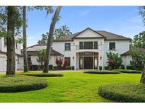 Stunning home with lush landscaping, mature trees, and a grand double-door entrance at 1455 Kelso Blvd, Windermere, FL 34786