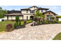 Stunning two-story home with stone accents, lush landscaping, and a brick paver driveway at 2245 Bronco Dr., St Cloud, FL 34771