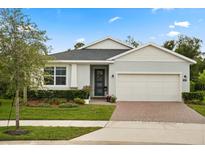 Charming single-story home features a well-manicured lawn, brick driveway, and attached two-car garage at 3635 Arbordale Loop, Sanford, FL 32771