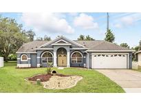 Charming single-story home with a well-manicured lawn, beautiful arched windows, and an attached two-car garage at 394 Hickory Springs Pl, Debary, FL 32713