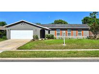 Charming single-story home with a well-maintained lawn and vibrant orange shutters, offering a welcoming curb appeal at 415 Seville Ave, Altamonte Springs, FL 32714