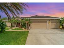 Charming single-story home featuring a fountain, a well-manicured lawn, and an attached two-car garage at 611 Curly Fern Ln, Deland, FL 32720