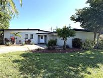 Charming single-story home featuring a well-manicured front yard with lush landscaping and mature trees at 6615 Beamer Way, Orlando, FL 32807