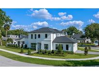 Stunning two-story home featuring manicured landscaping and modern architectural details under a sunny, partly cloudy sky at 734 Terra Pl, Maitland, FL 32751