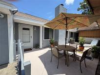 Charming patio area with outdoor seating, perfect for relaxing or entertaining guests under the shade of a large umbrella at 737 Tanglewood Rd, Winter Springs, FL 32708