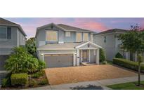 Beautiful two-story home featuring a brick driveway, two-car garage, and well-maintained landscaping at 7647 Fairfax Dr, Kissimmee, FL 34747